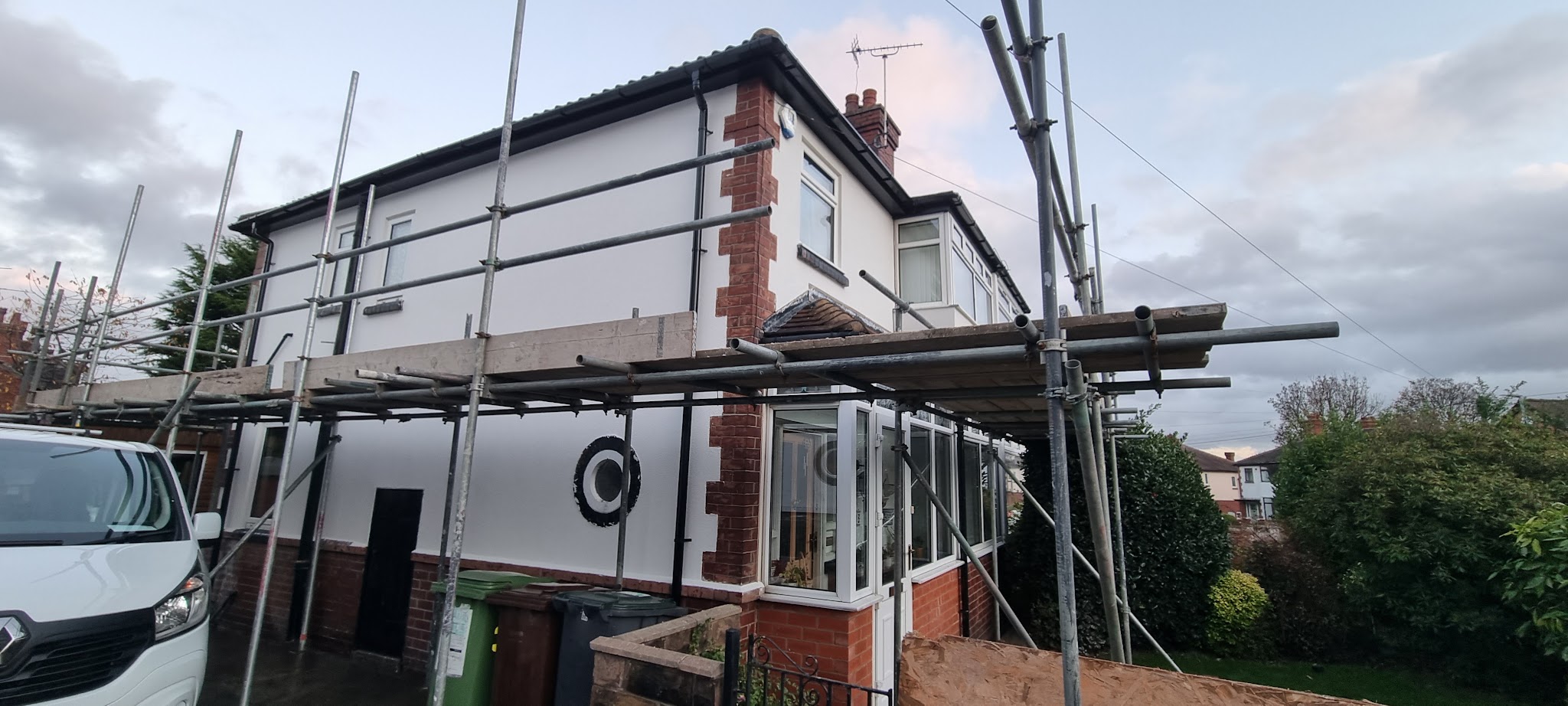 Rendering work around the brick details of a house on scaffolding