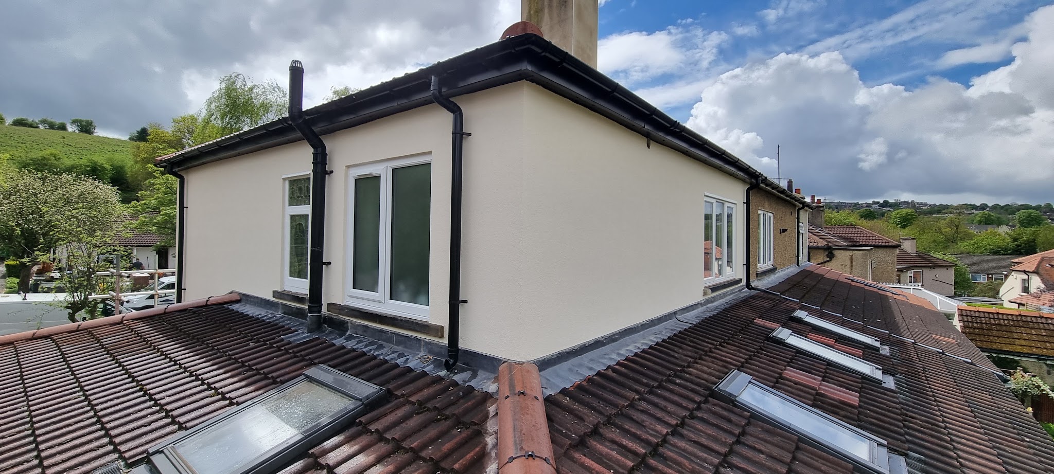 Finished pale render around upper windows and roof junctions
