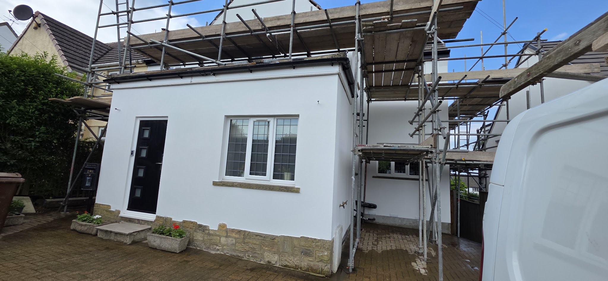 Rendered entrance and window reveals with scaffolding in place